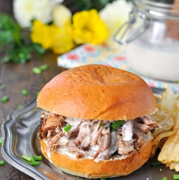 Slow cooker pulled pork with alabama white bbq sauce on a sandwich bun