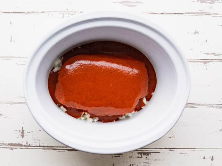 Pouring bbq sauce over the chuck roast.