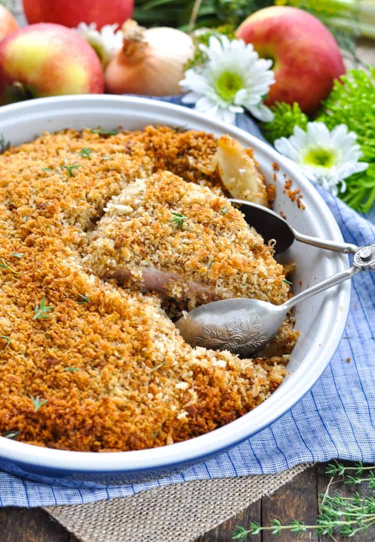 Boneless pork chops in a casserole dish with serving spoons