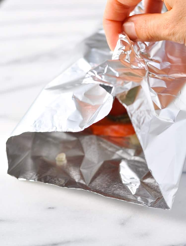 A process shot of wrapping a fillet of salmon in foil