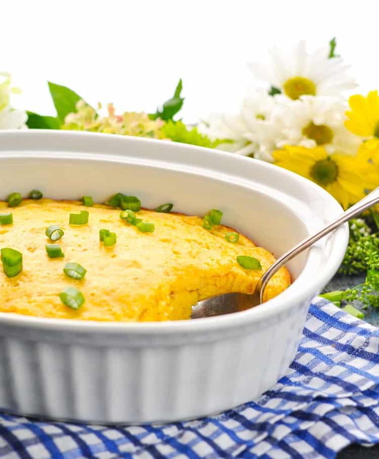 A side shot of a corn pudding in a white dish