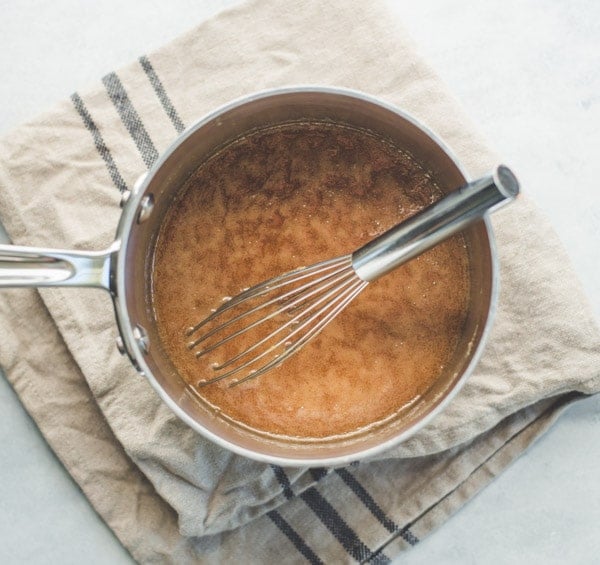 Caramel sauce in saucepan with whisk