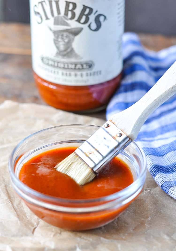 BBQ sauce in a small glass bowl with a pastry brush