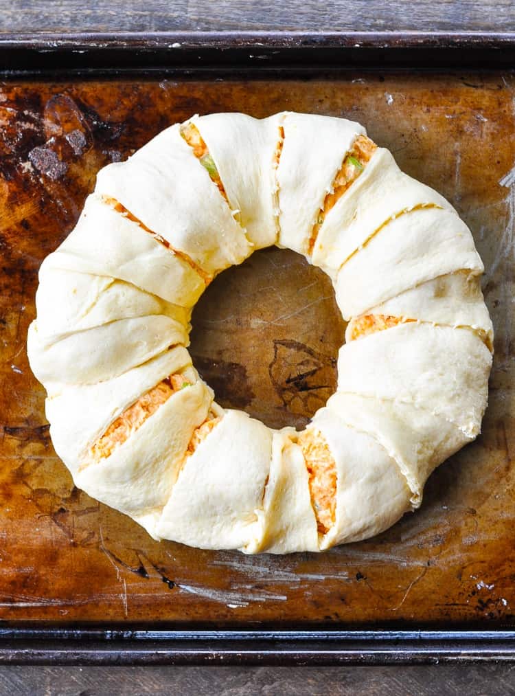 An overhead shot of a Buffalo Chicken Dip Crescent Ring on a baking tray