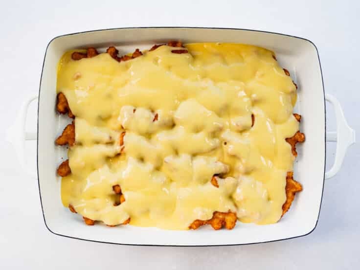 Spreading creamy sauce over chicken nuggets.