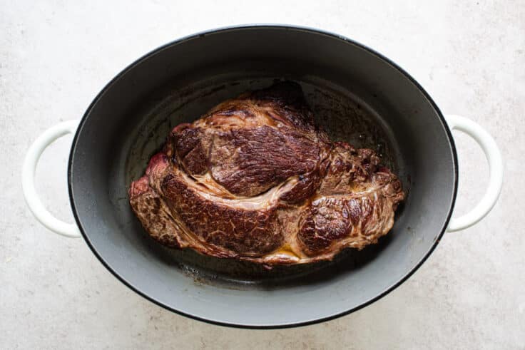 Searing a roast in a pot.