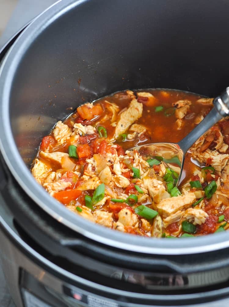 Mexican chicken in a slow cooker with a serving spoon