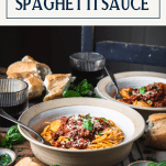 Side shot of homemade spaghetti sauce served over noodles with text title box at top
