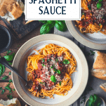 Overhead shot of two bowls of the best spaghetti sauce served with pasta and text title overlay at top