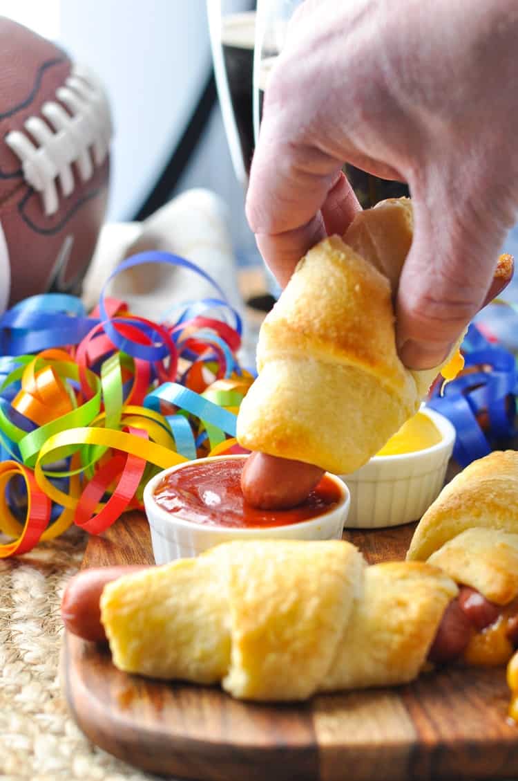 Cheesy Crescent Dogs dipped in ketchup.