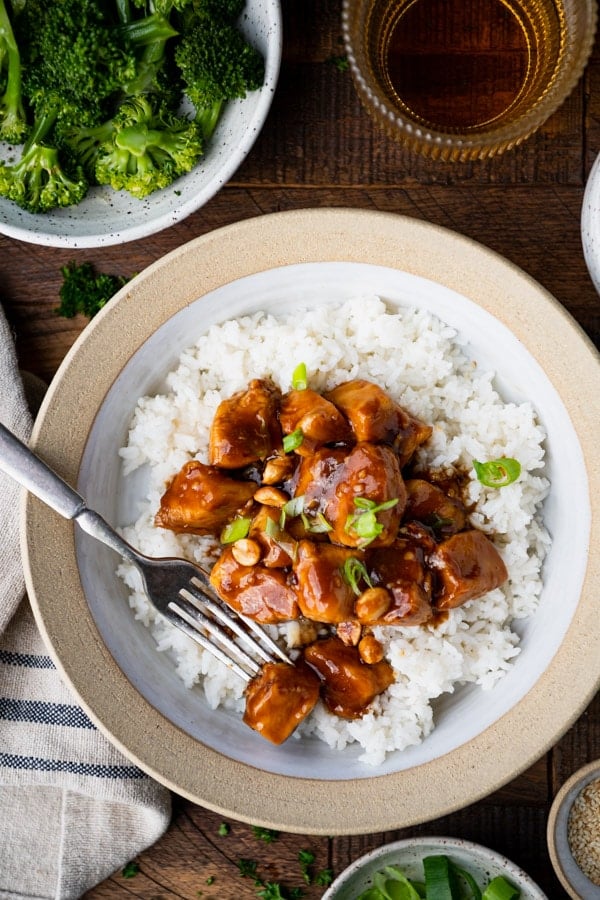 Fork in a bowl of healthy general tso chicken with rice
