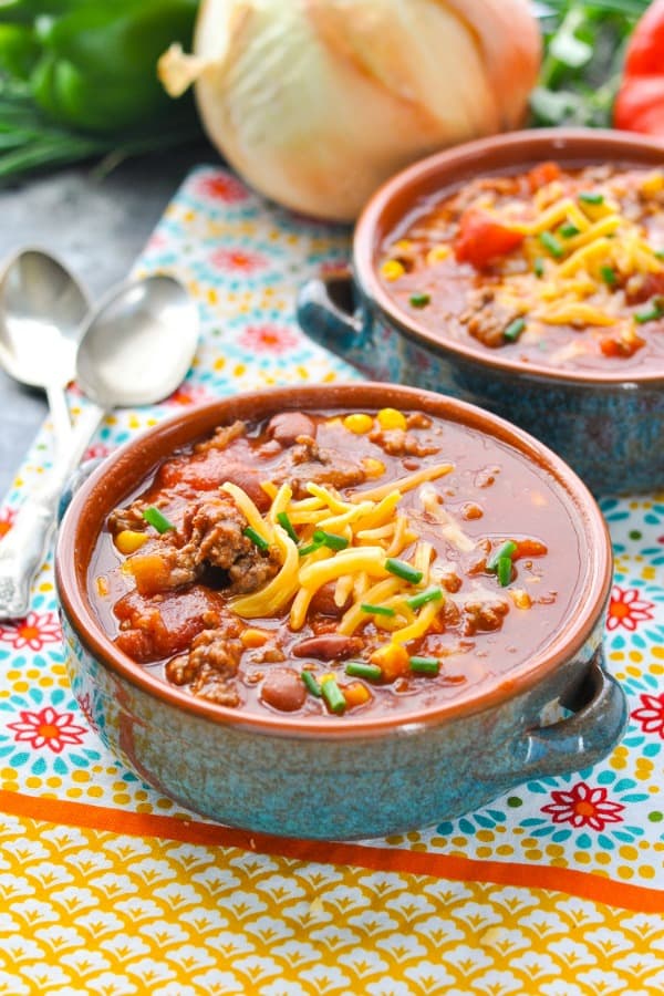 Bowl of easy slow cooker chili with cheese and green onion on top