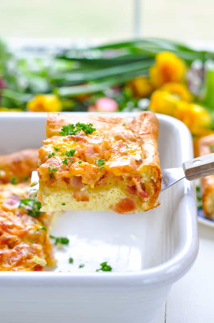 A slice of 5 ingredient breakfast casserole in a baking dish with a spatula removing a slice
