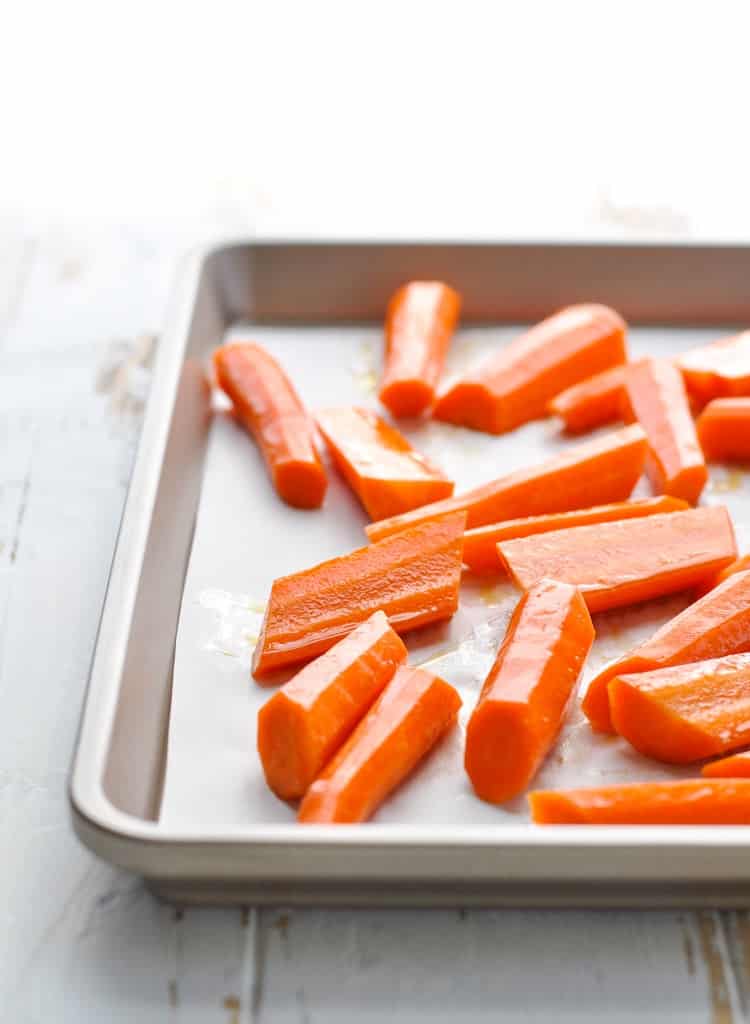 Raw sliced carrots on a baking sheet