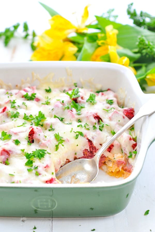 5 ingredient Reuben Casserole in a green baking dish with a silver serving spoon