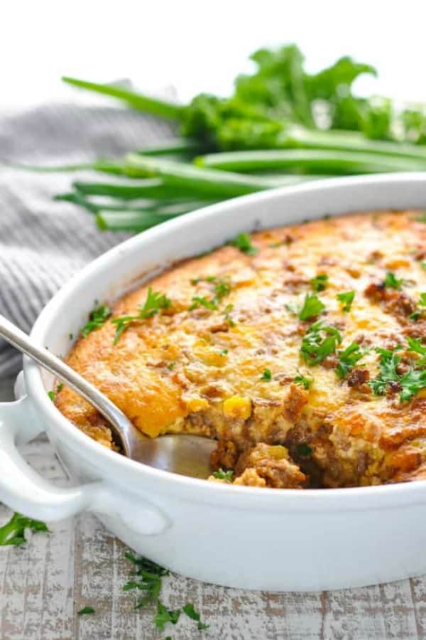 Cheeseburger Pie in a white casserole dish garnished with fresh parsley