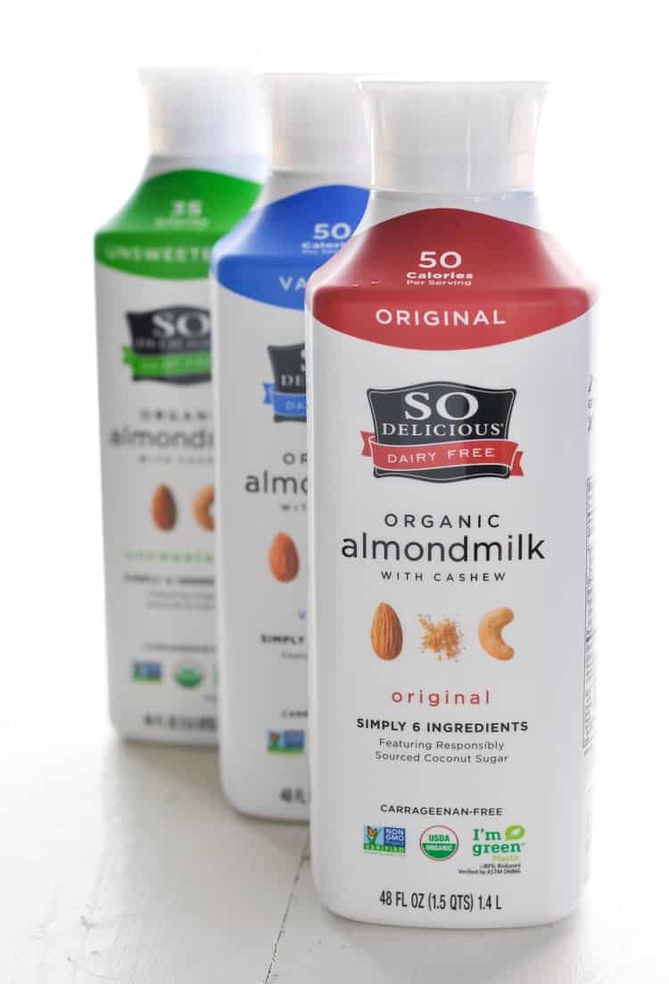 Three bottles of So Delicious almondmilk used to make a healthy strawberry smoothie