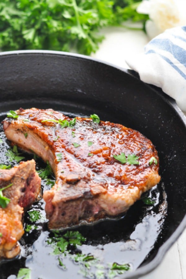 Thick pan fried pork chop in a cast iron skillet