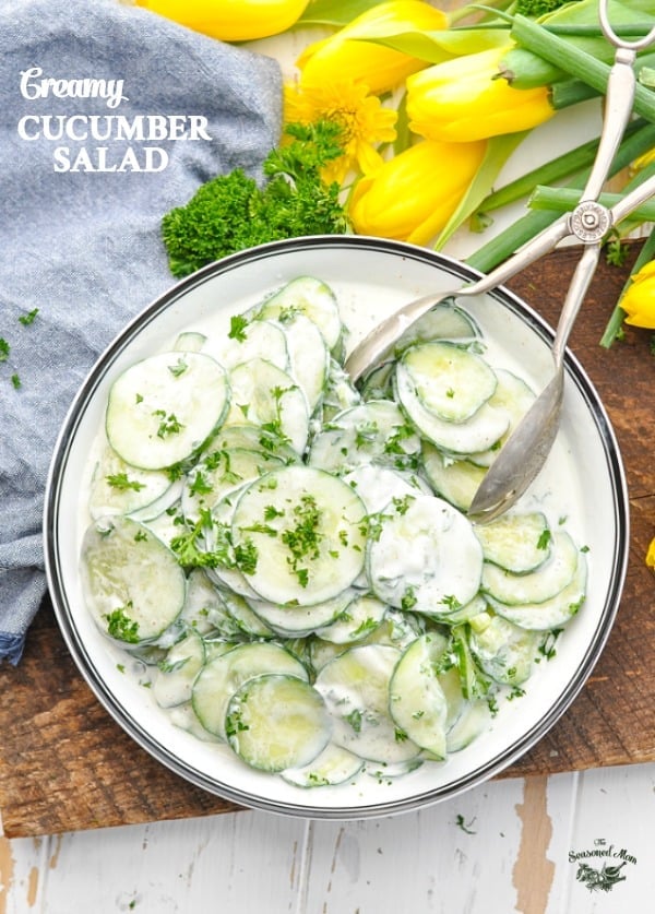 Overhead image of bowl with Creamy Cucumber Salad and yellow tulips.