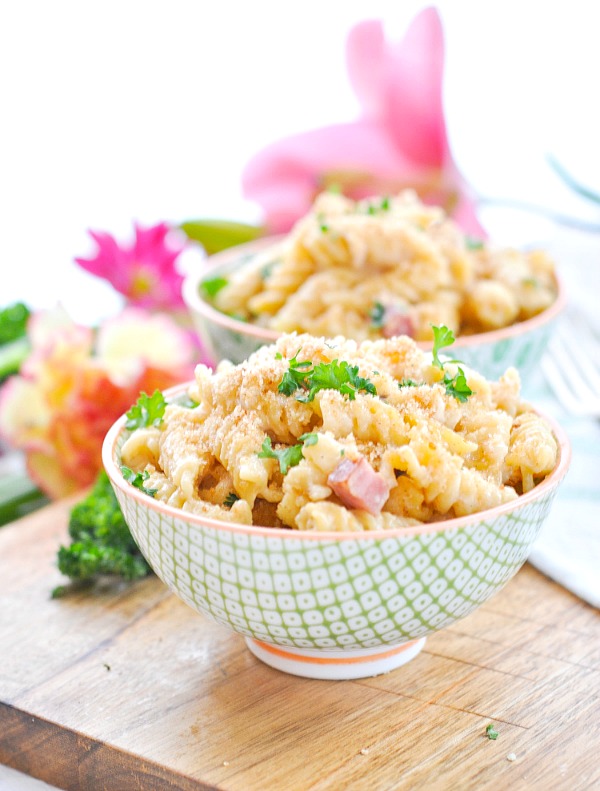 Chicken and ham pasta casserole in green and white bowls