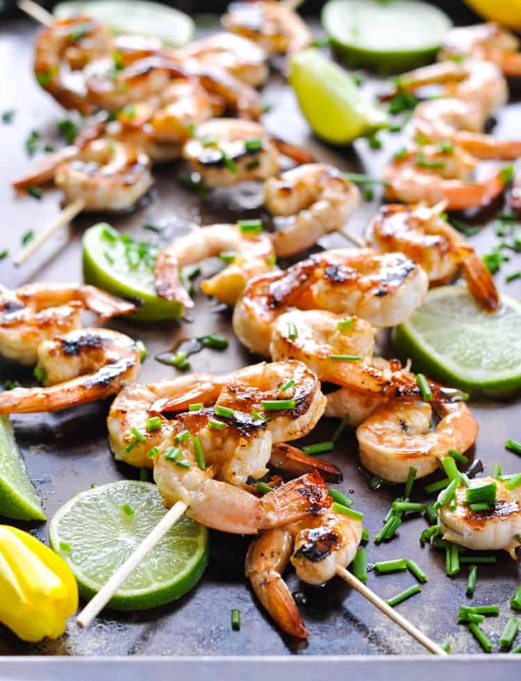 Tray of honey lime grilled shrimp garnished with fresh chives.