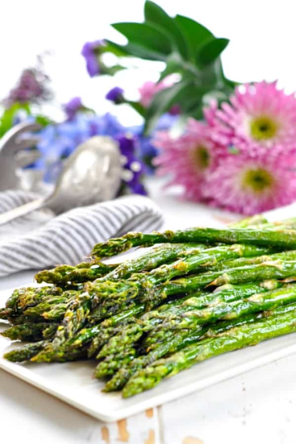 Oven roasted asparagus on a white serving platter