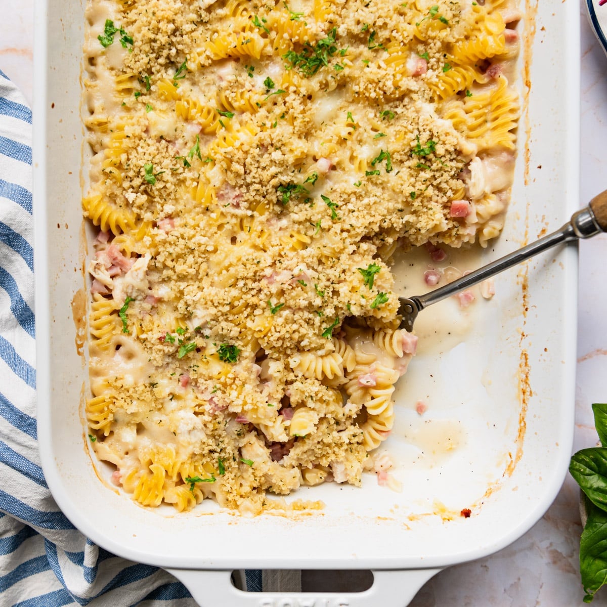 Square overhead shot of a chicken cordon bleu casserole in a white baking dish.