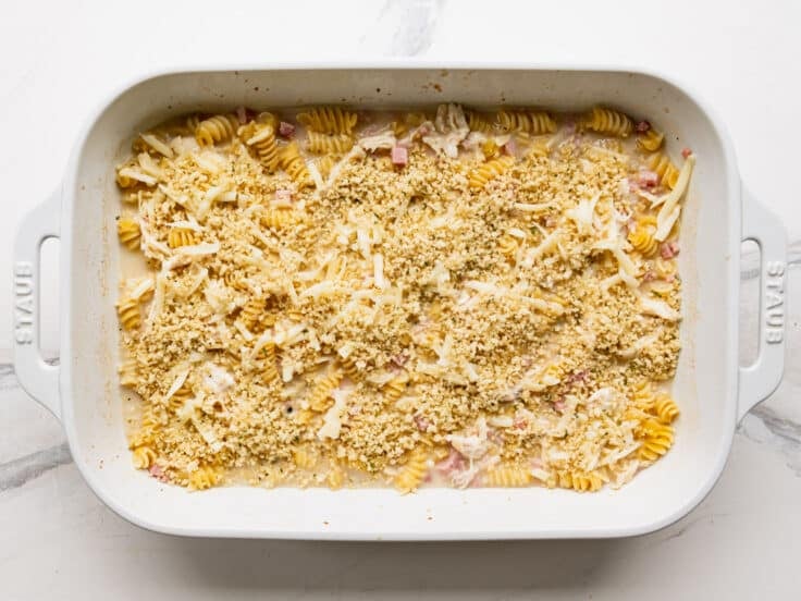Adding the breadcrumbs to the top of the casserole.