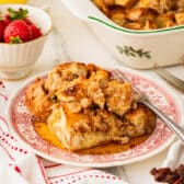 Horizontal side shot of French toast casserole on a plate with syrup.