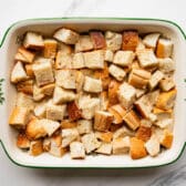 Adding the custard to bread cubes.