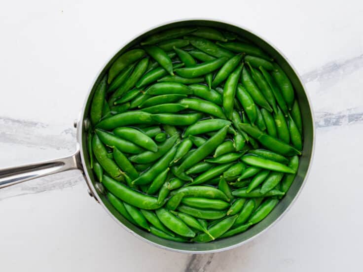 Process shot showing how to cook sugar snap peas.