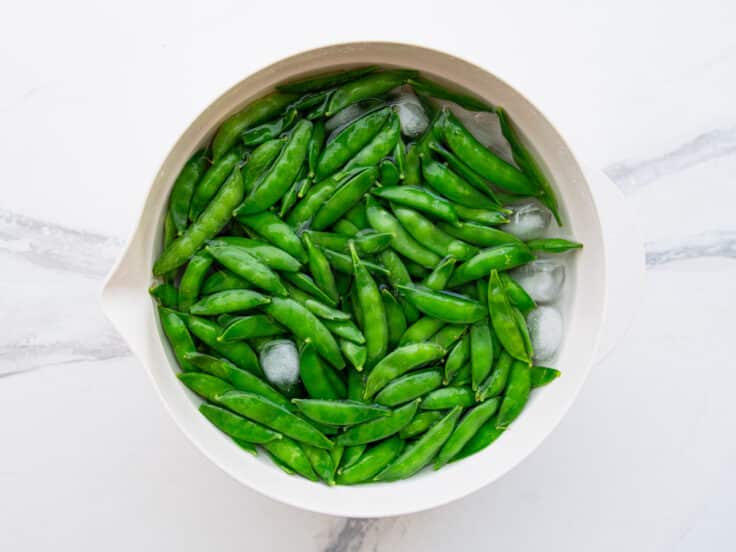 Sugar snap peas in an ice bath.