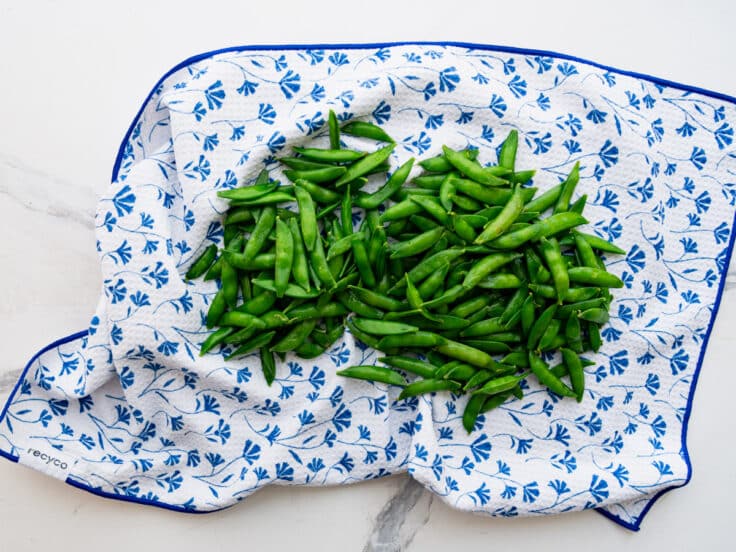 Drying sugar snap peas on a dish towel.