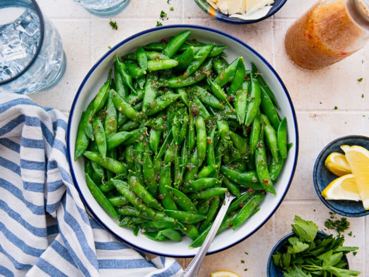 Horizontal overhead image of a bowl of sugar snap peas.