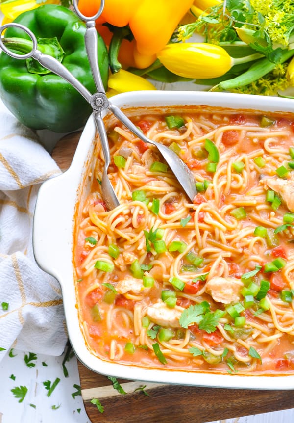 An overhead image of a casserole of baked chicken spaghetti - a creamy casserole with spaghetti, chicken, and veggies.