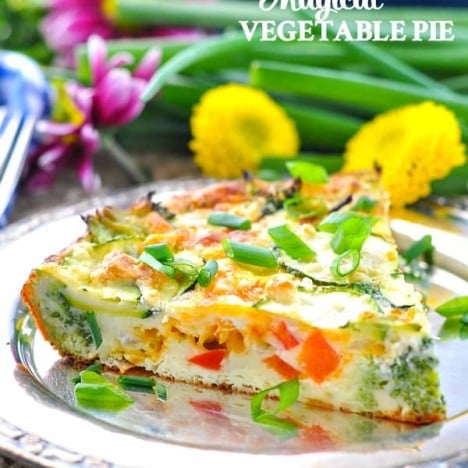 Slice of easy Vegetable Pie on a plate with flowers in the background