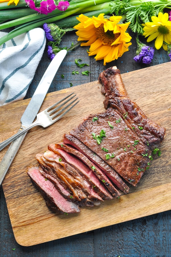 Overhead image of sliced ribeye steak on a cutting board