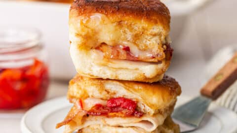 Square side shot of Kentucky hot brown sliders on a white plate.