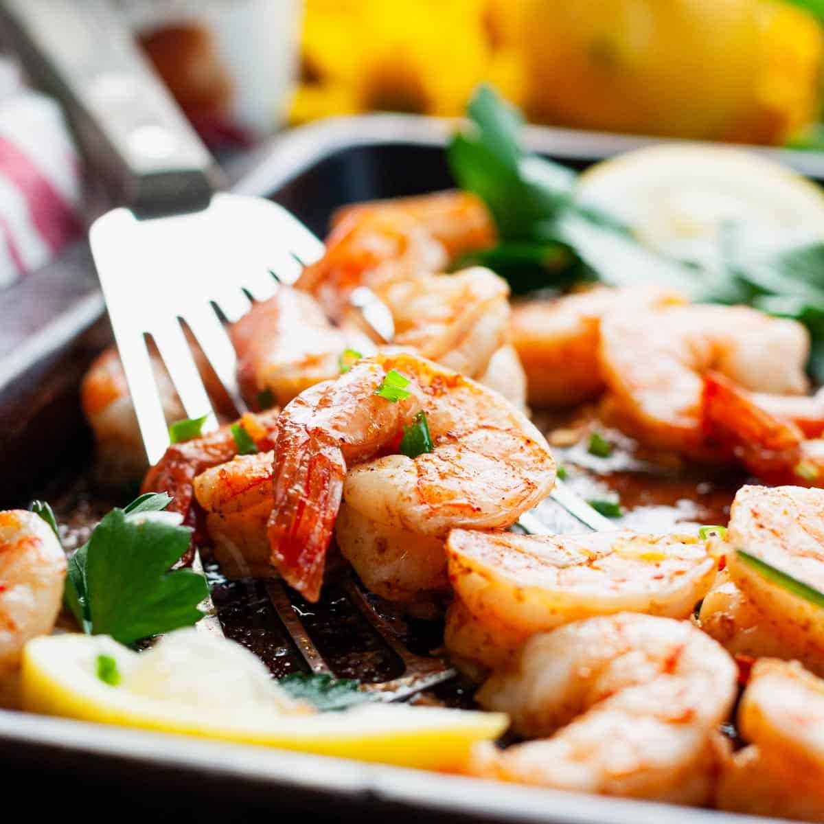 A baked barbecue shrimp recipe on a sheet pan.
