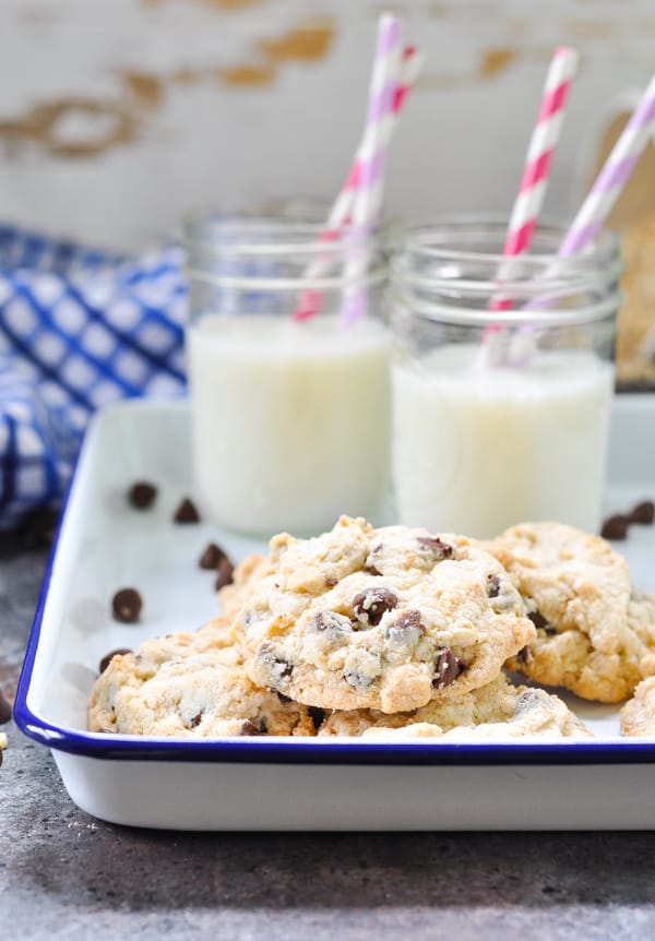 Tray of homemade oatmeal chocolate chip cookies with glasses of milk