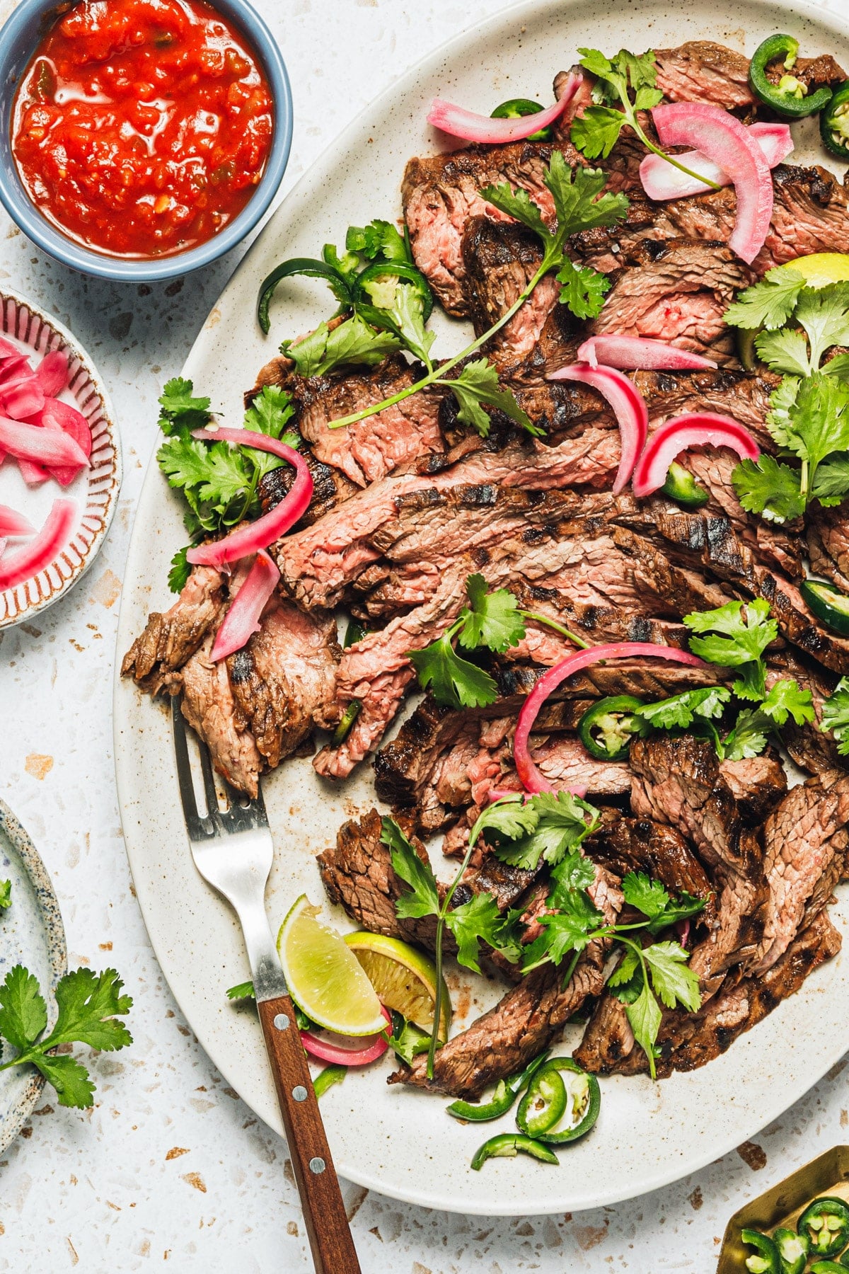 Overhead shot of a white tray full of sliced carne asada.