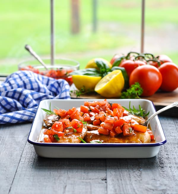 A sheet pan filled with Bruschetta Chicken - balsamic glazed chicken breasts topped with a Bruschetta tomato and basil topping.