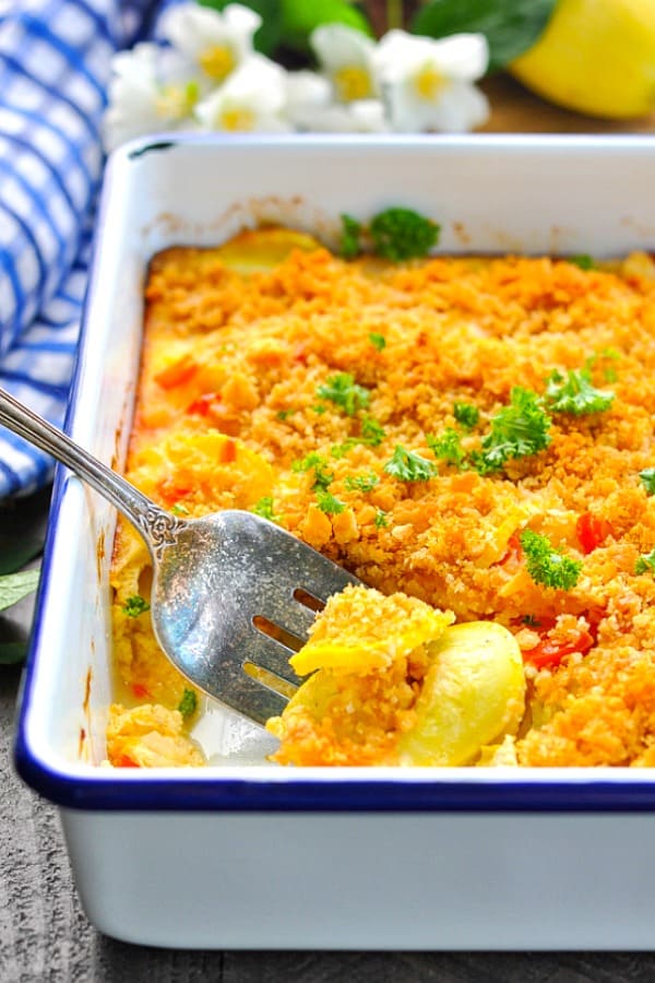 Close up shot of Southern Yellow Summer Squash Casserole in a blue and white baking dish with crumb topping