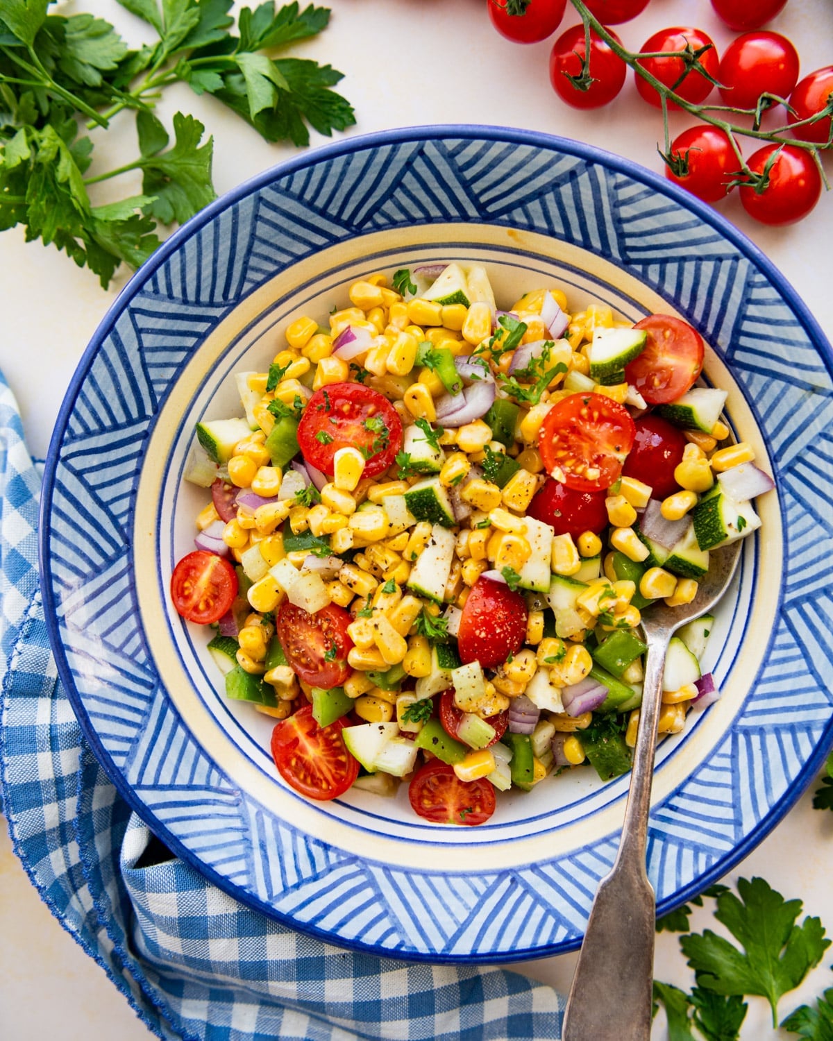 Overhead shot of a healthy and fresh corn salad in a blue serving bowl.