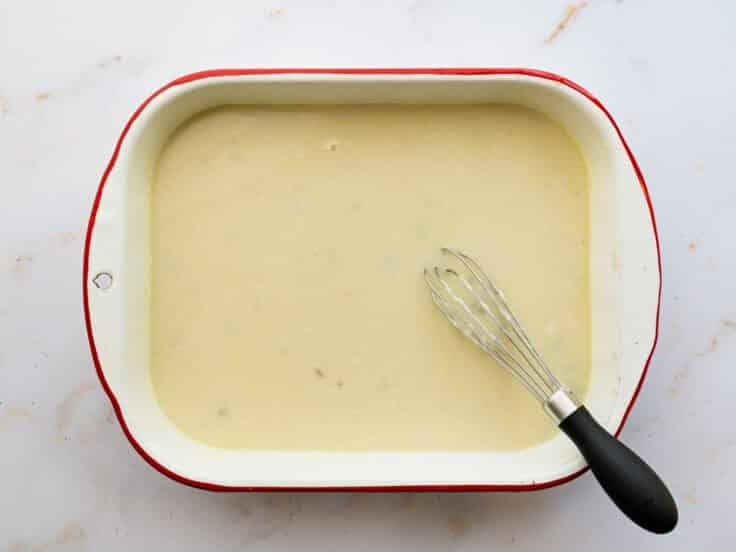 Whisking the creamy sauce in the baking pan.