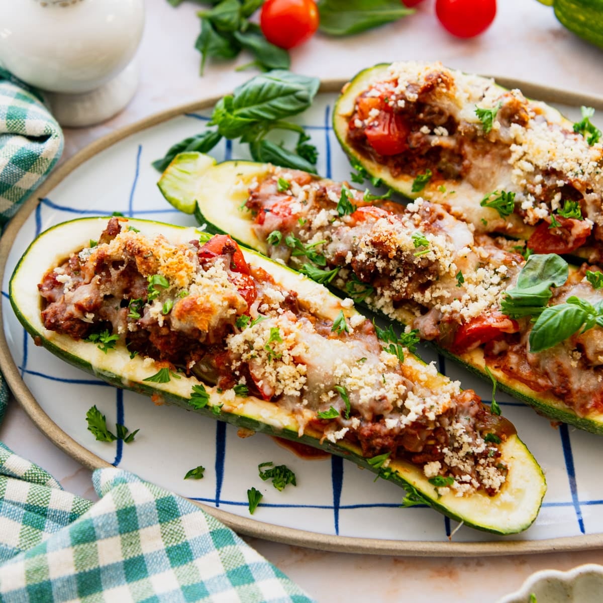 Square side shot of stuffed zucchini boats on a serving platter.