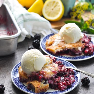 The best blackberry cobbler on a blue plate topped with ice cream