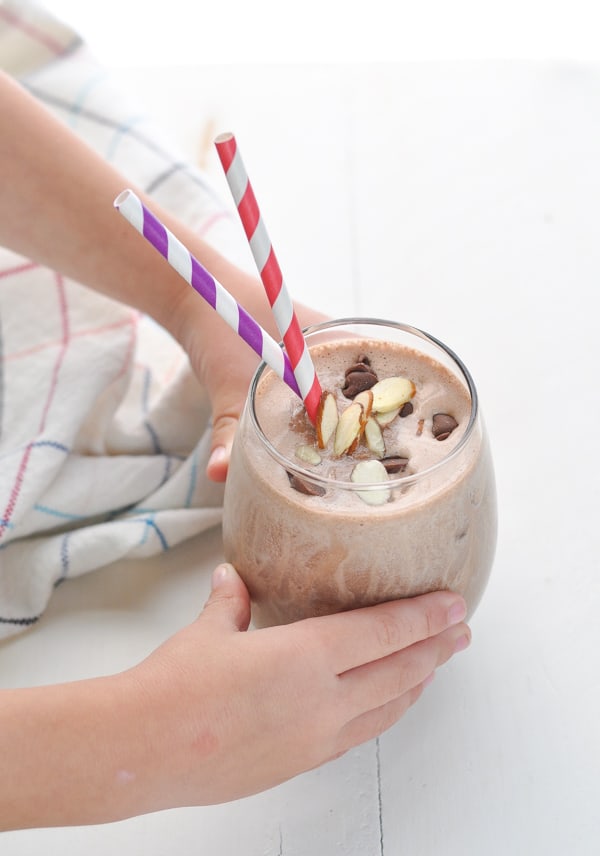 Child holding chocolate protein smoothie