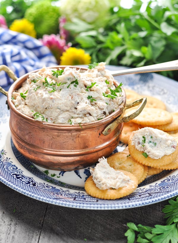 Close image of crab dip in a copper bowl and crab dip spread on crackers