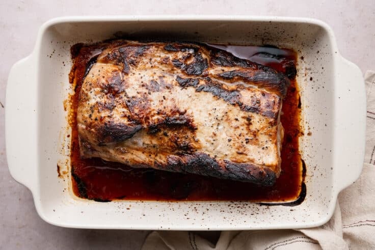 Overhead shot of a roasted pork loin in a dish.